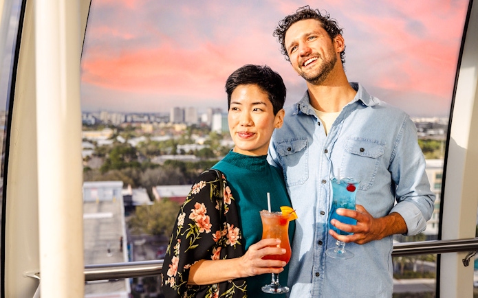Couple enjoying drinks on the observation wheel at ICON Park, Orlando.
