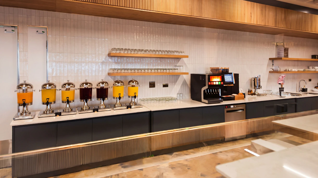Beverage station with juice dispensers and coffee machine at The Phoenix Lounge, Dublin Airport Terminal 1.
