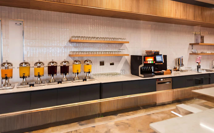 Beverage station with juice dispensers and coffee machine at The Phoenix Lounge, Dublin Airport Terminal 1.