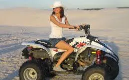 Quad biking on sand dunes during a sandboarding and quad biking tour.