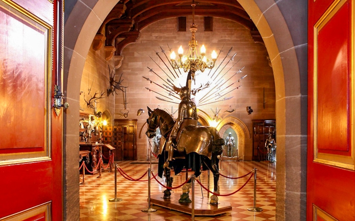 Warwick Castle interior with knight armor display and medieval decor.
