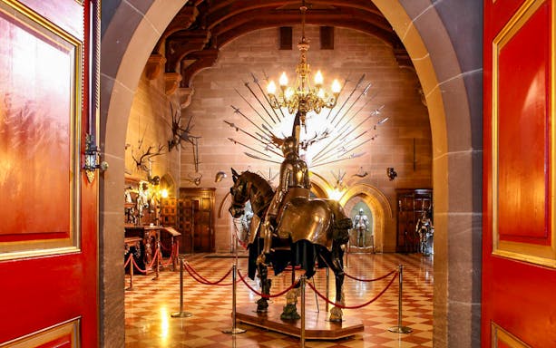 Warwick Castle interior with knight armor display and medieval decor.