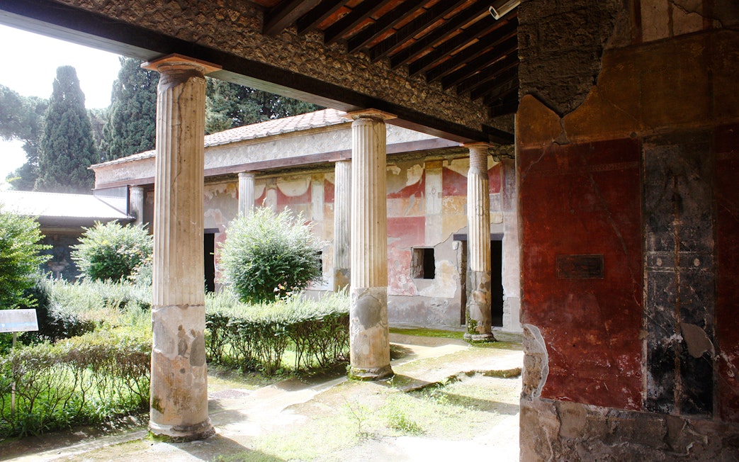 Courtyard with columns and frescoes at Pompeii ruins, Italy.