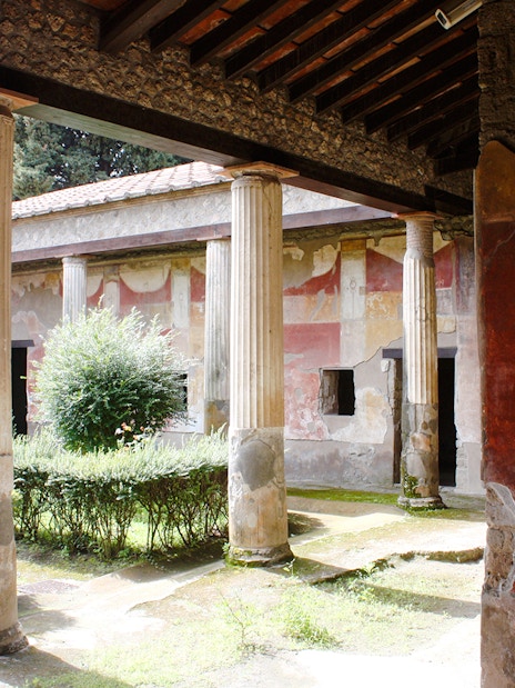 Courtyard with columns and frescoes at Pompeii ruins, Italy.