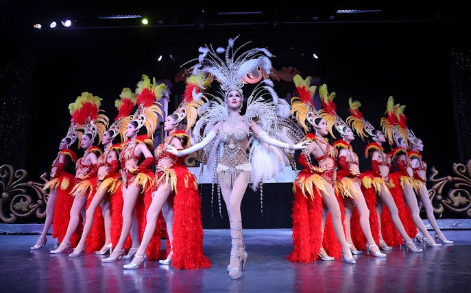 Performers in vibrant costumes on stage at Miracle Cabaret Show.
