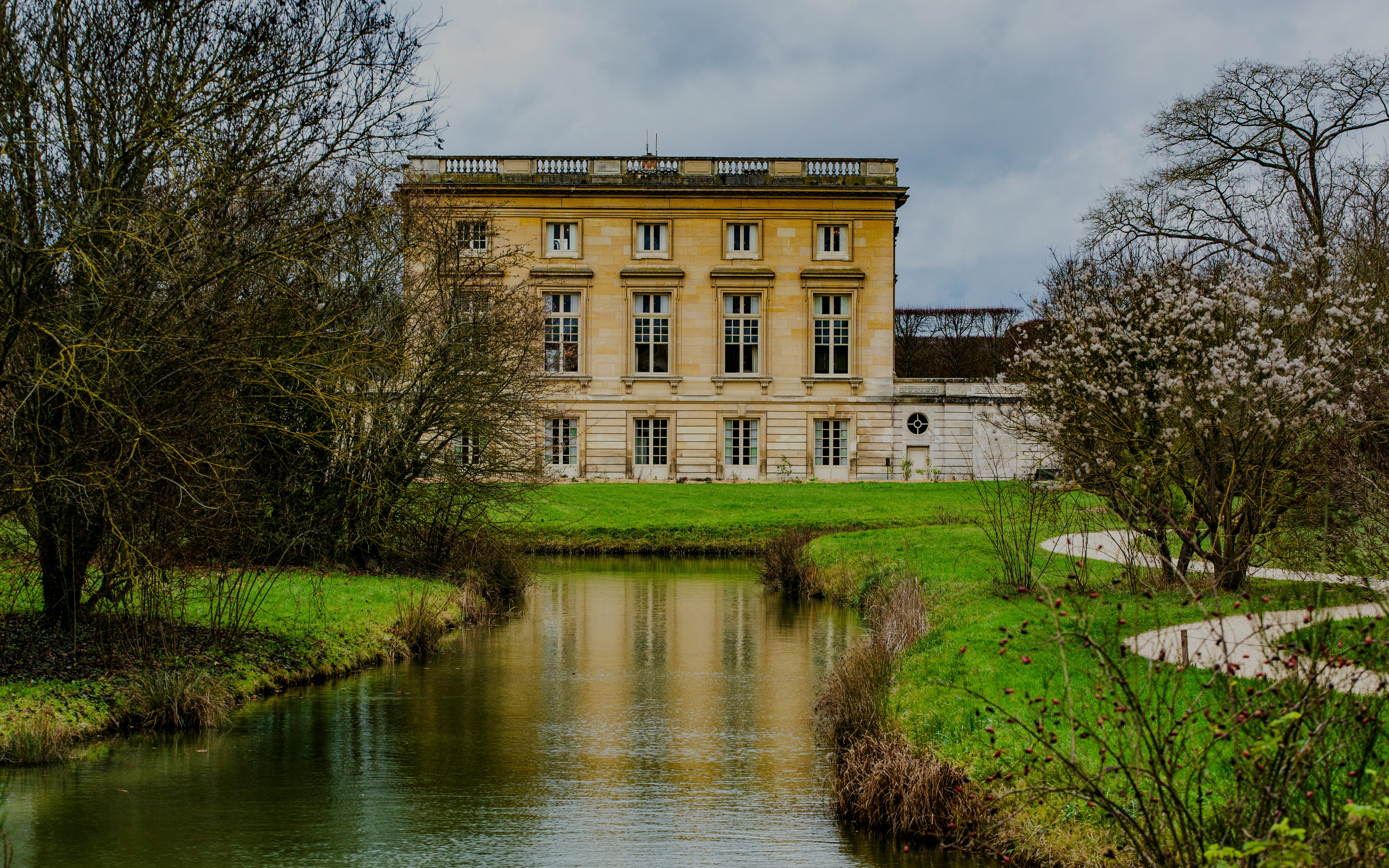 Grand Trianon building with surrounding gardens and canal in Versailles, France.