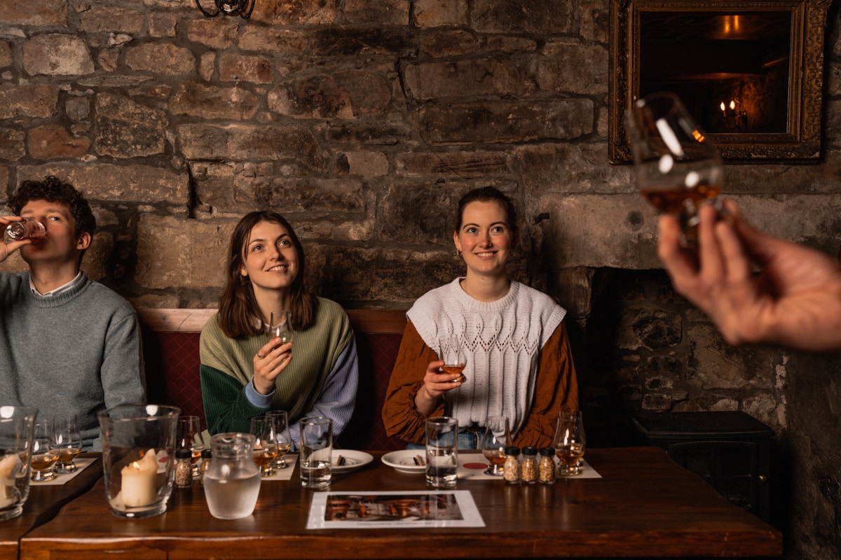 Guests enjoying whisky tasting at an underground tour in Edinburgh.