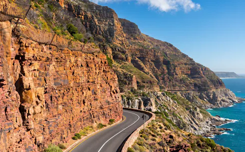 Winding coastal road along rocky cliffs at Cape of Good Hope, Cape Town.