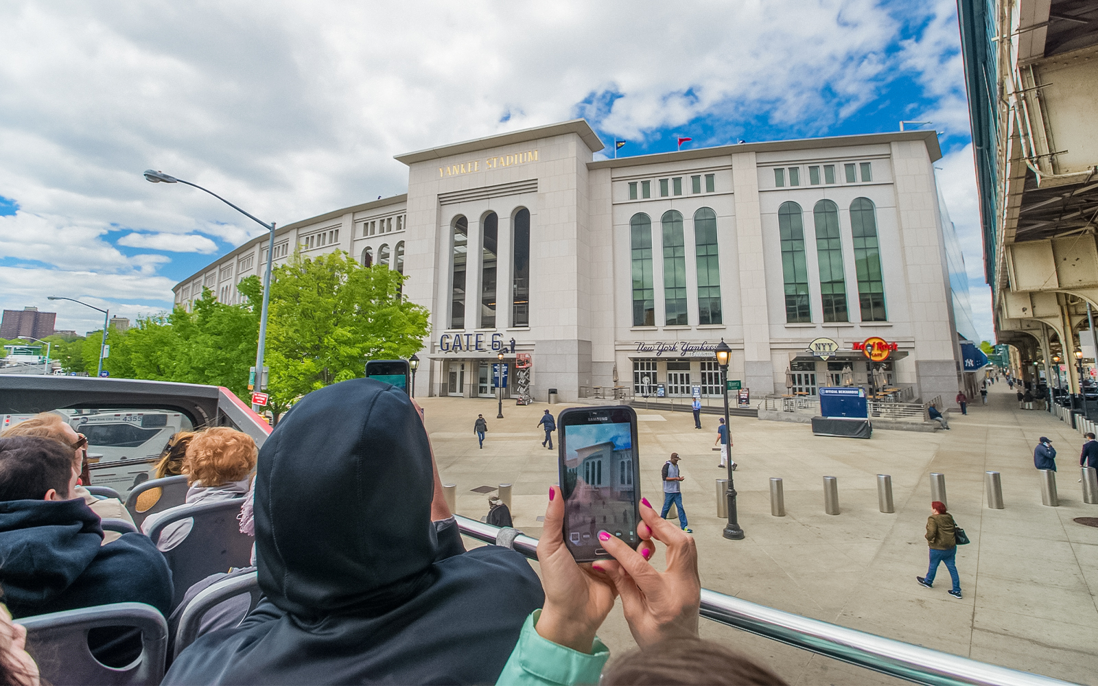 Passenger taking photos on a hop-on hop-off bus tour in New York City.