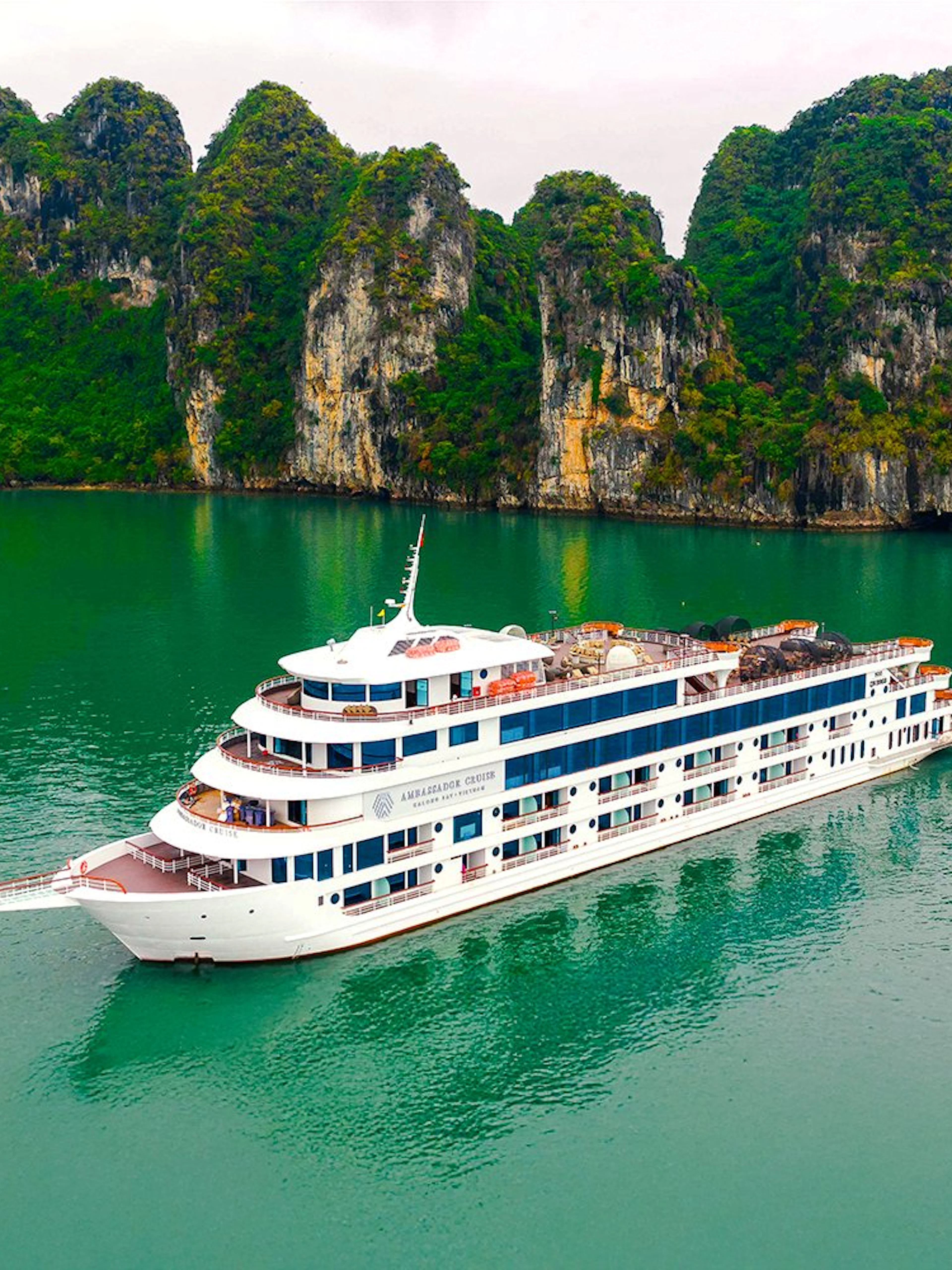 Aerial view of Ambassador cruise ship in Halong Bay, Vietnam, near limestone islands.