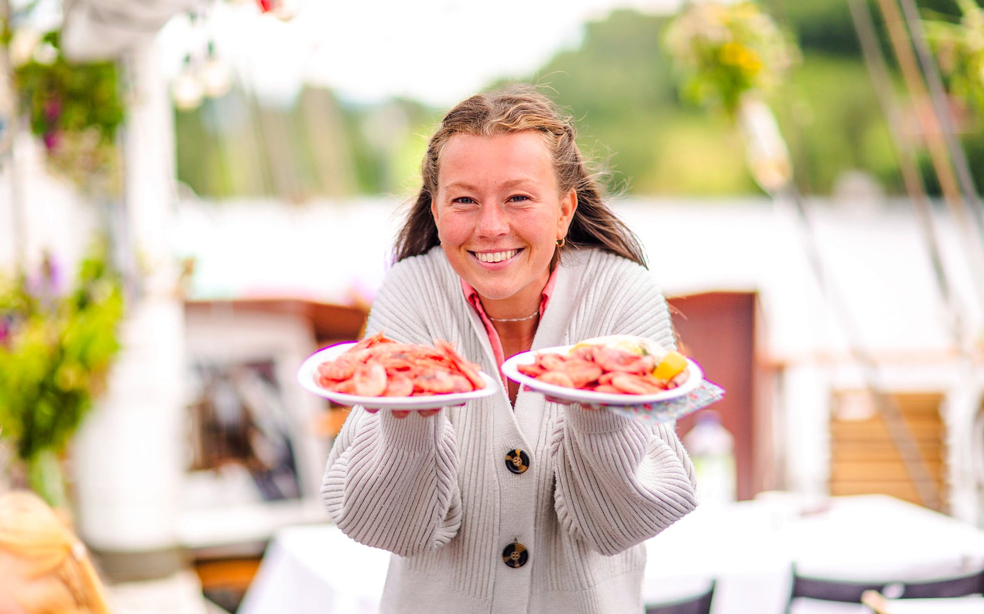 Staff presenting seafood plates on Oslofjord dinner cruise.