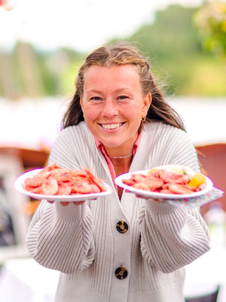 Staff presenting seafood plates on Oslofjord dinner cruise.