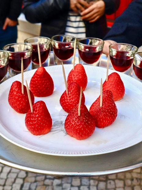 Strawberries and glasses of wine on a tray during Lisbon food tour.