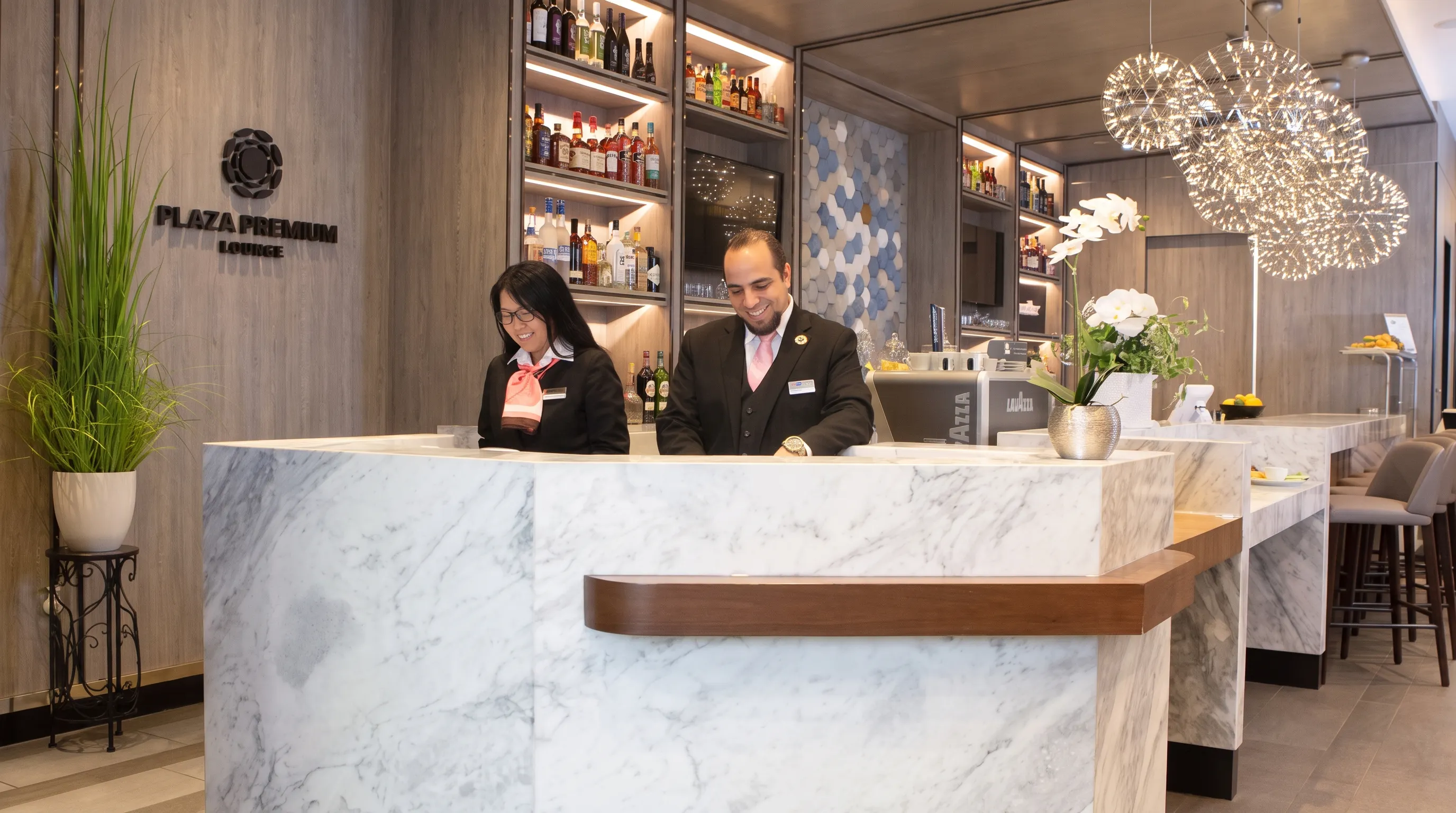 Staff at reception desk in Plaza Premium Lounge, Dallas Fort Worth International Airport Terminal E.