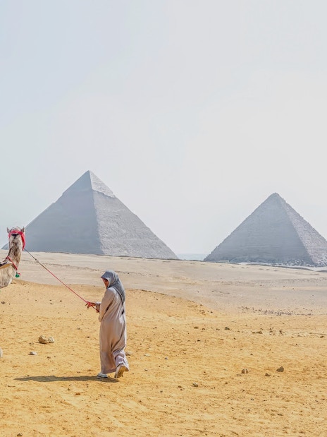 Woman riding a camel near the pyramids at Giza Necropolis, Cairo day trip from Hurghada.