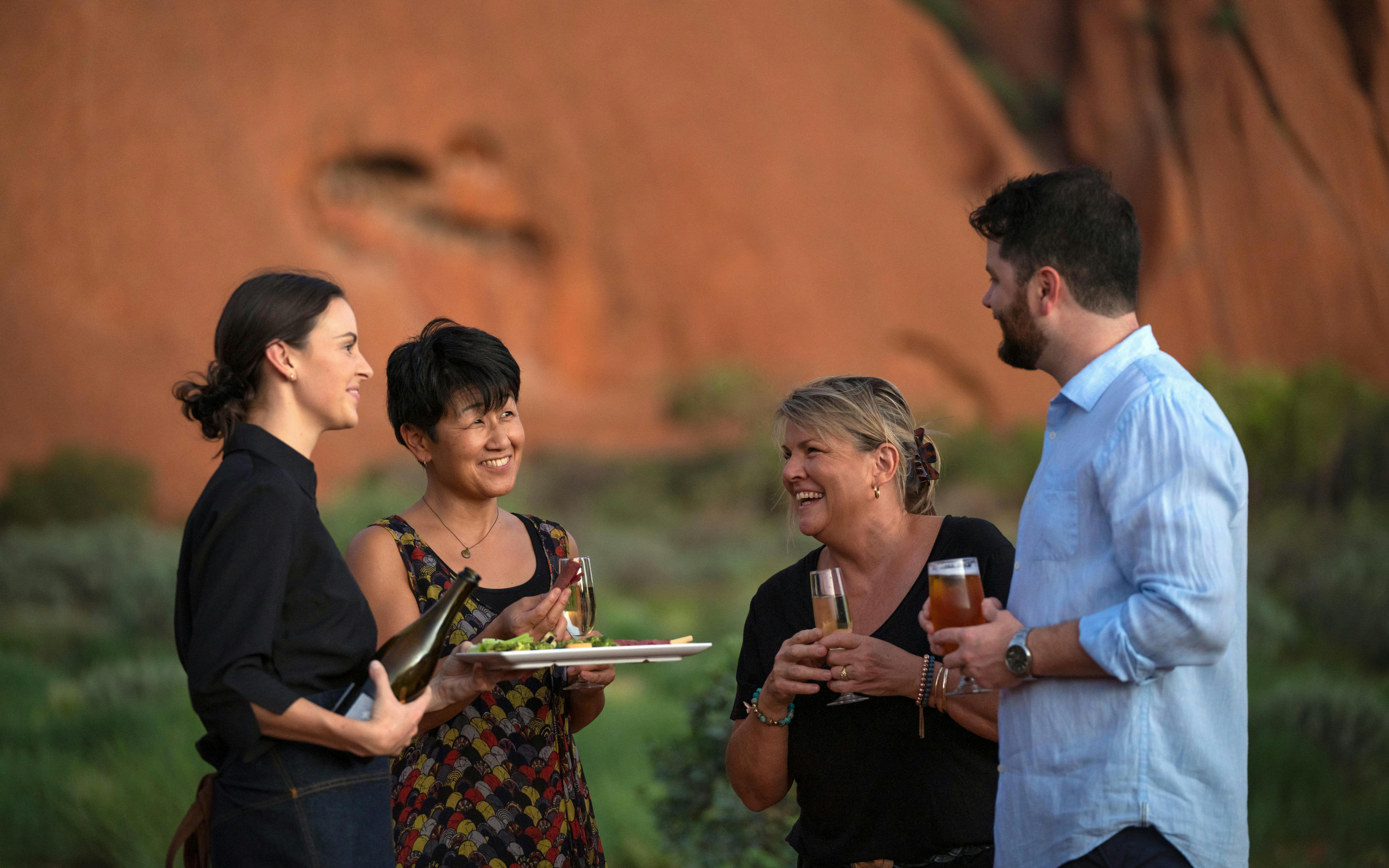 Guests enjoying drinks at Uluru during sunset on a stargazing tour with BBQ dinner.