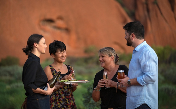 Guests enjoying drinks at Uluru during sunset on a stargazing tour with BBQ dinner.