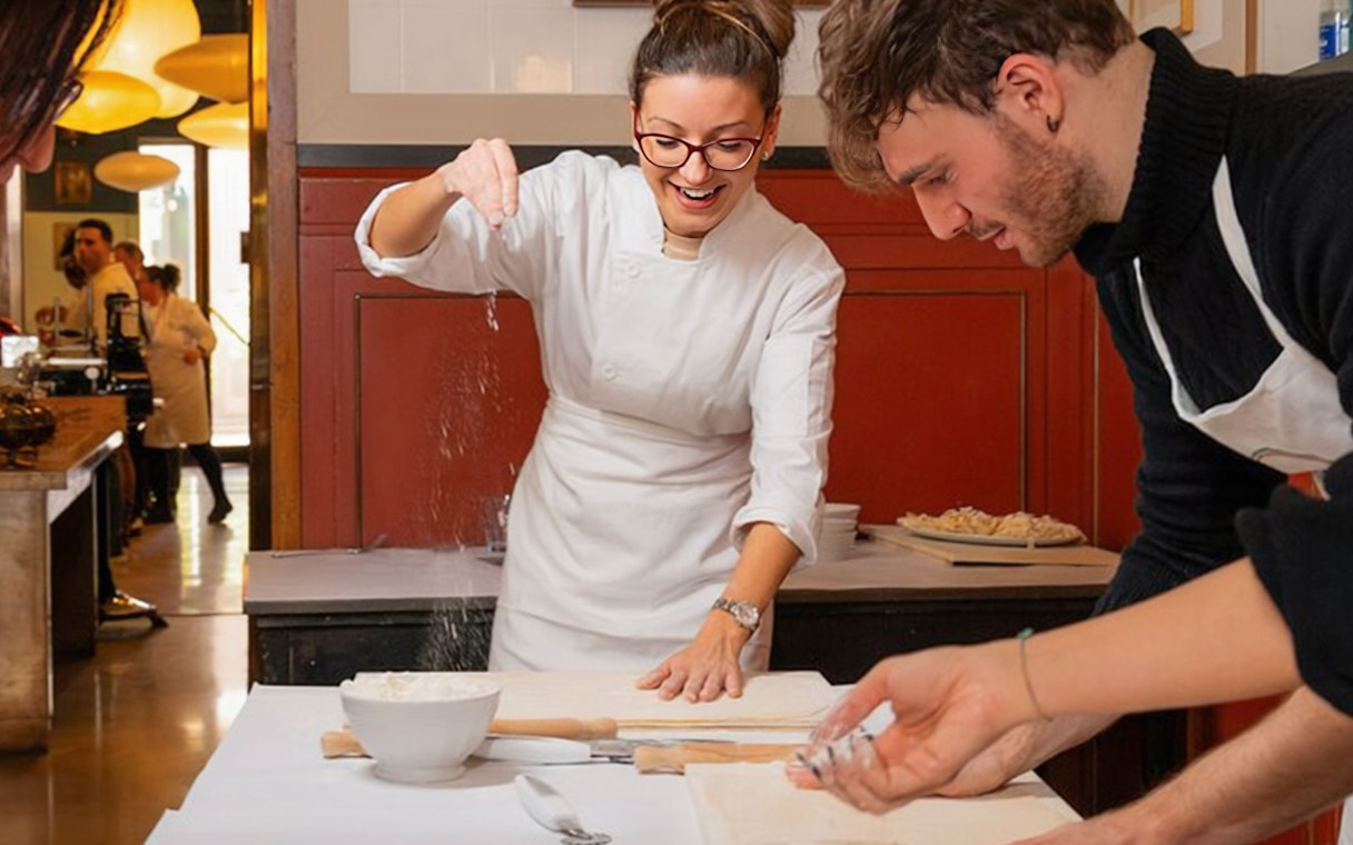 Preparing pasta at a cooking class in Rome, with participants learning techniques.