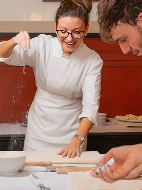 Preparing pasta at a cooking class in Rome, with participants learning techniques.