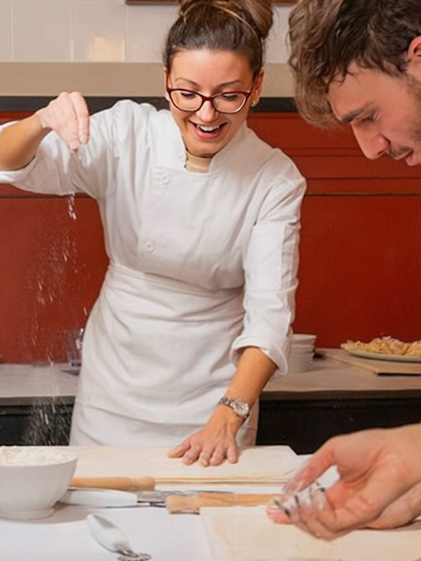 Preparing pasta at a cooking class in Rome, with participants learning techniques.