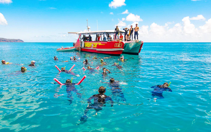 Snorkelers near Thundercat boat in Whitsundays, Australia, enjoying a full day tour.
