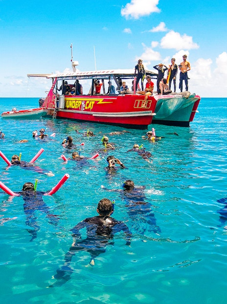 Snorkelers near Thundercat boat in Whitsundays, Australia, enjoying a full day tour.