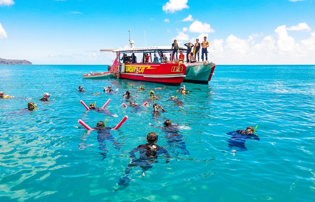 Snorkelers near Thundercat boat in Whitsundays, Australia, enjoying a full day tour.