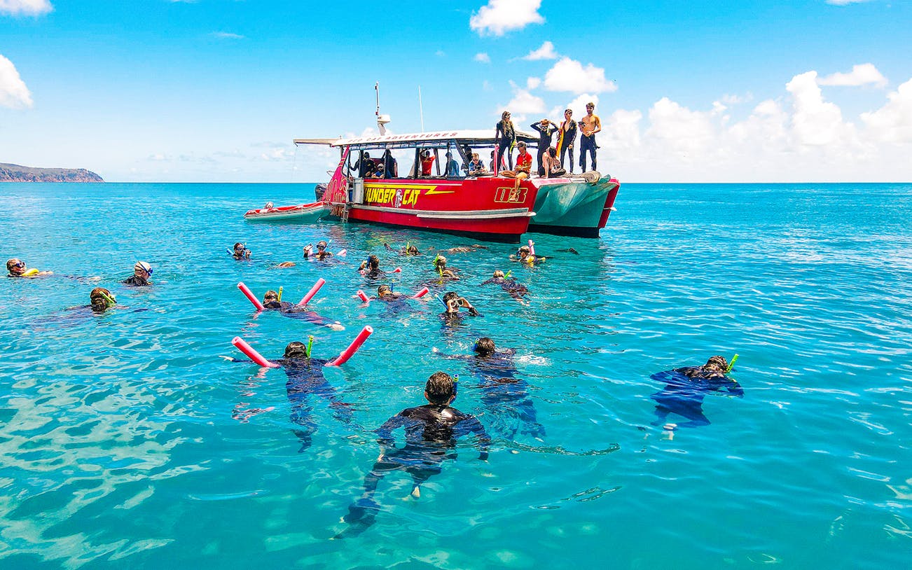 Snorkelers near Thundercat boat in Whitsundays, Australia, enjoying a full day tour.