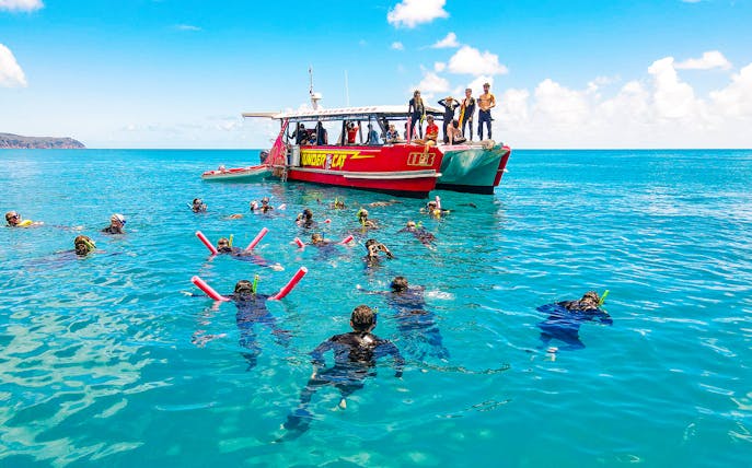 Snorkelers near Thundercat boat in Whitsundays, Australia, enjoying a full day tour.
