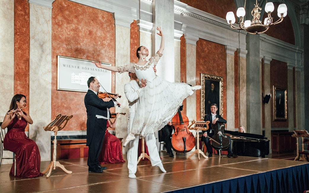 Vienna Residence Orchestra performing with ballet dancer at Old Stock Exchange Palace.