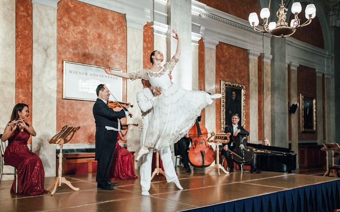 Vienna Residence Orchestra performing with ballet dancer at Old Stock Exchange Palace.