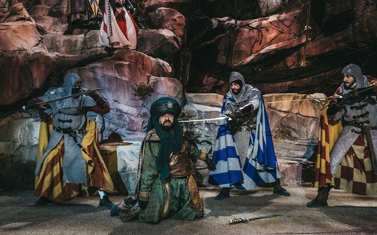 Medieval reenactment at Puy du Fou España with knights and a Moorish figure in Toledo.