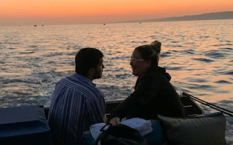 Couple enjoying a sunset dinner cruise on the waters of Marseille.