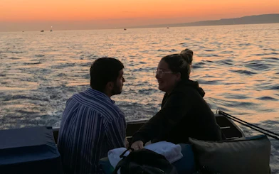 Couple enjoying a sunset dinner cruise on the waters of Marseille.