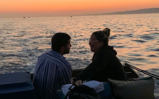 Couple enjoying a sunset dinner cruise on the waters of Marseille.