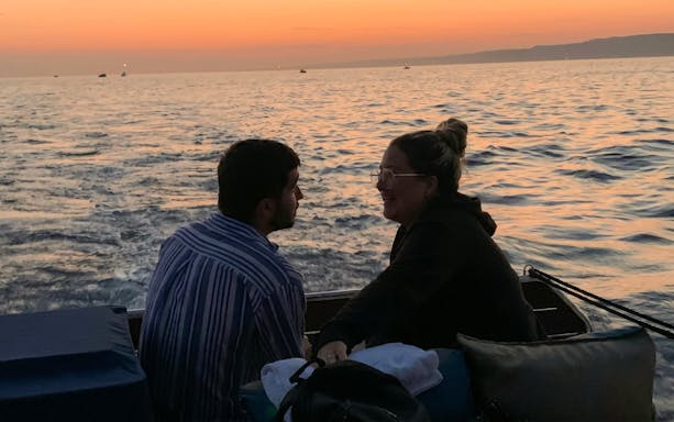 Couple enjoying a sunset dinner cruise on the waters of Marseille.