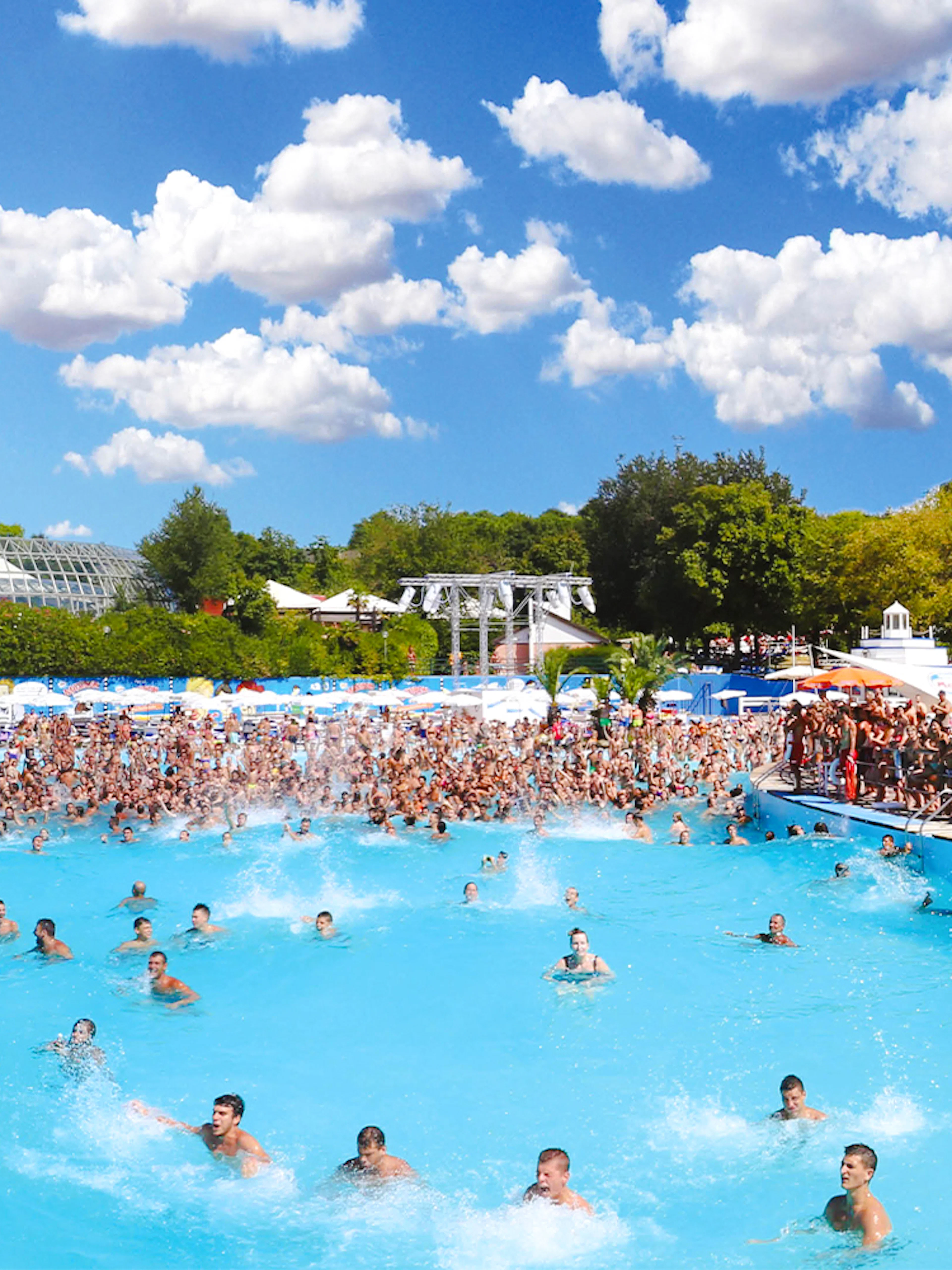 Crowded wave pool at Aquafan Water Park with people swimming and splashing.