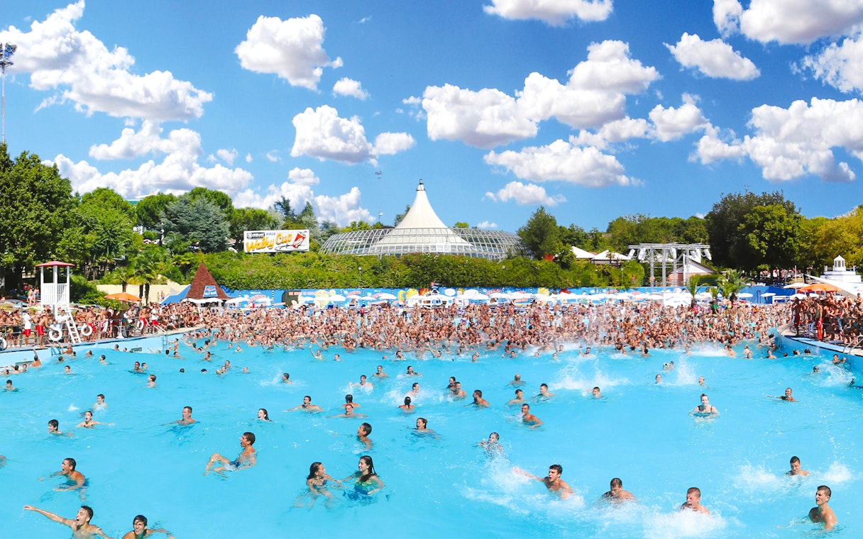 Crowded wave pool at Aquafan Water Park with people swimming and splashing.