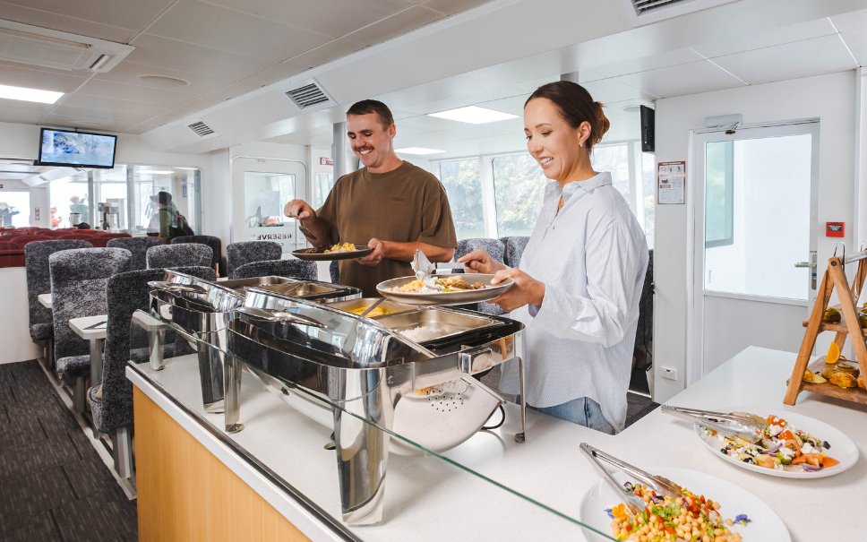 Guests enjoying buffet on Milford Sound nature cruise ship.