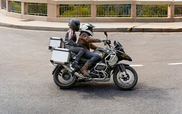 Motorcyclists riding a BMW R1250GS on a road near Montserrat, Barcelona.