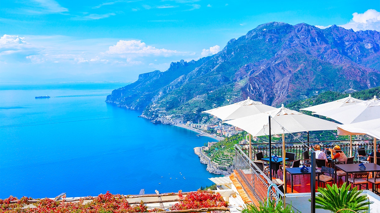 Dining area with tables and chairs overlooking the Amalfi Coast, Rome to Positano route.