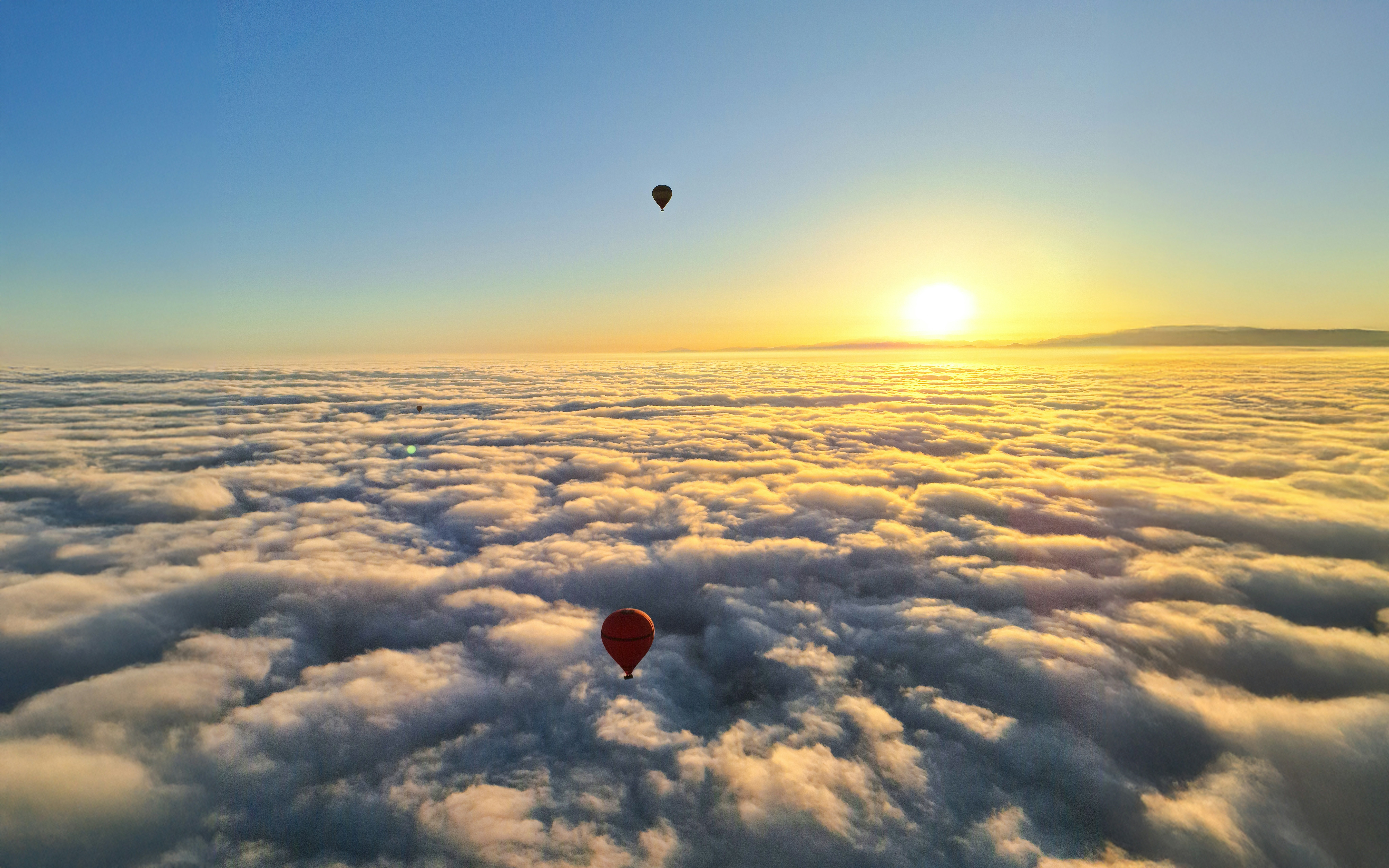 Hot air balloons above clouds at sunrise, Marrakech.
