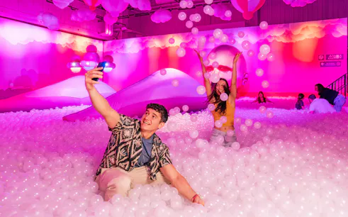 Visitors enjoying the Immersive Bubble Planet exhibit with colorful spheres in Singapore.