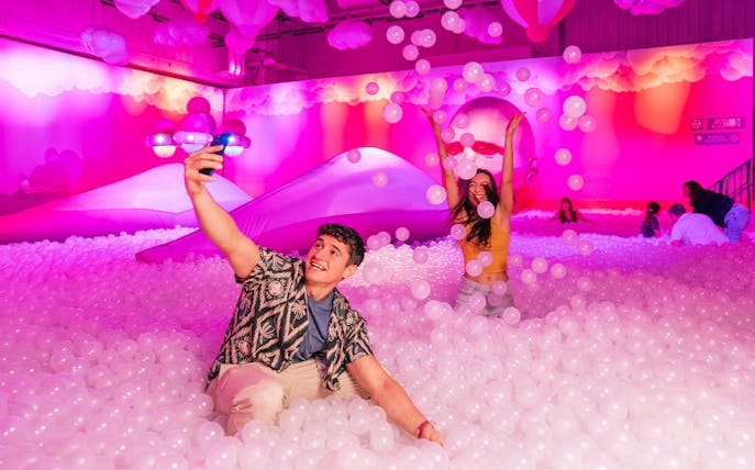 Visitors enjoying the Immersive Bubble Planet exhibit with colorful spheres in Singapore.