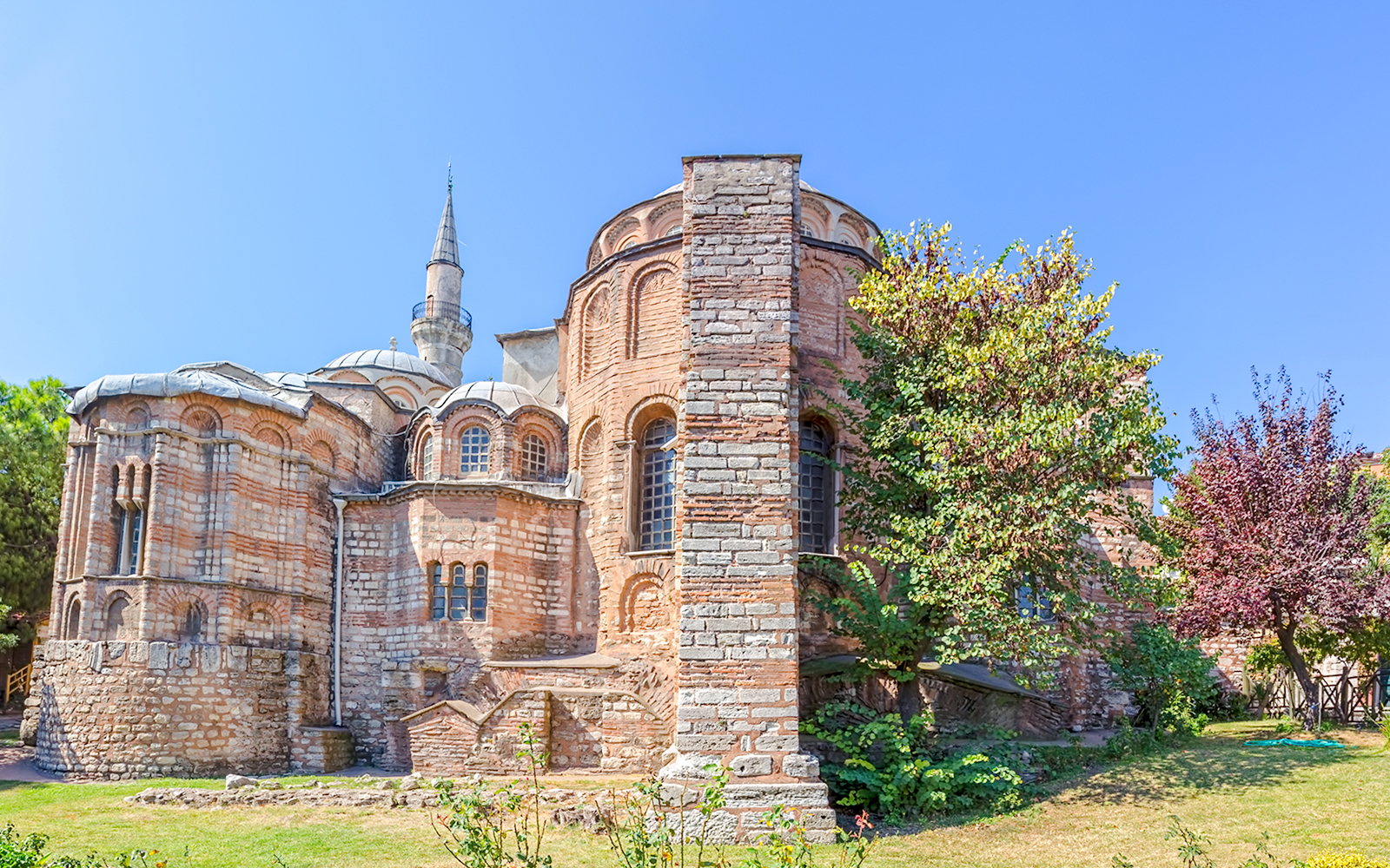 Kariye Mosque exterior with brickwork and minaret in Istanbul.