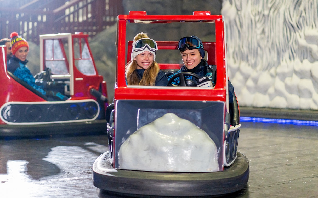Visitors enjoying bumper cars at Ski Dubai indoor snow park, Dubai, UAE.
