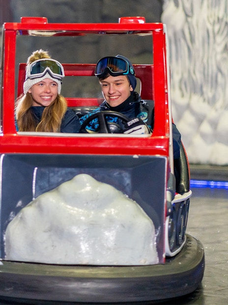 Visitors enjoying bumper cars at Ski Dubai indoor snow park, Dubai, UAE.