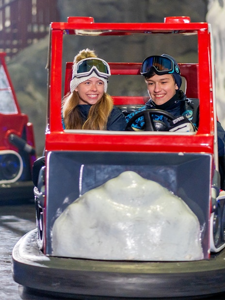 Visitors enjoying bumper cars at Ski Dubai indoor snow park, Dubai, UAE.