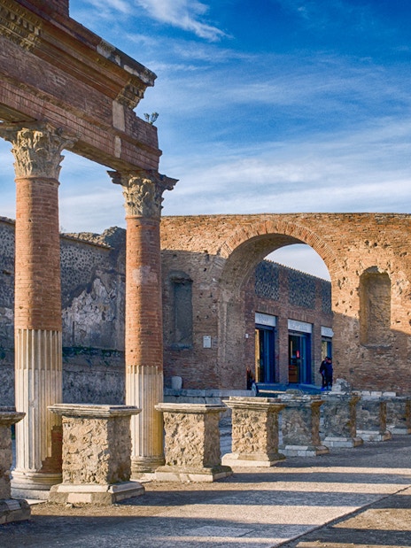 Ancient ruins of Pompeii with Mount Vesuvius in the background.