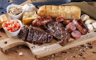 Grilled meats and sides on a wooden board at a Brazilian steakhouse in Rio de Janeiro.